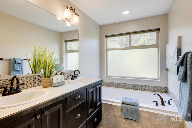 bathroom with double vanity, a bath, tasteful backsplash, and a sink