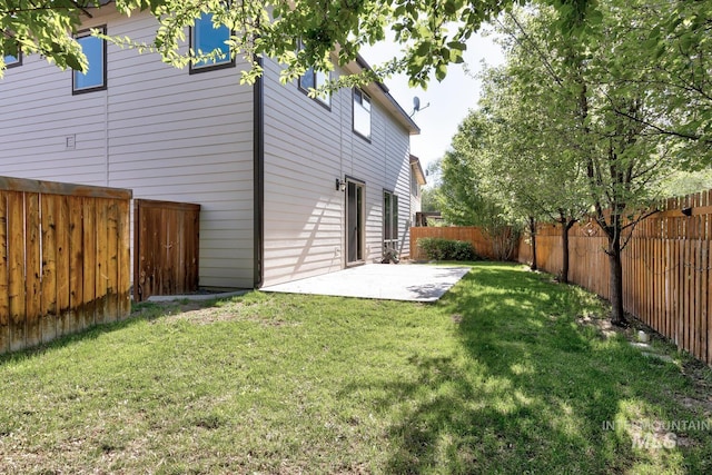 rear view of house with a patio area, a lawn, and a fenced backyard