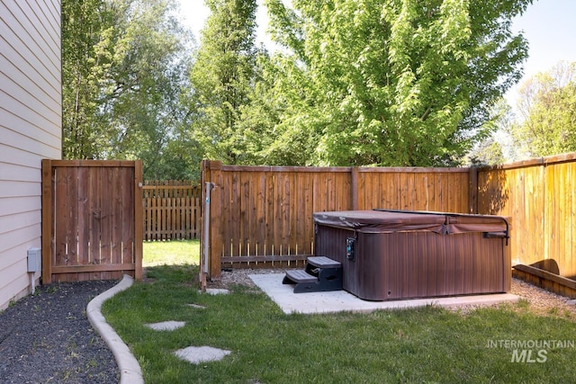 view of yard featuring a hot tub and a fenced backyard