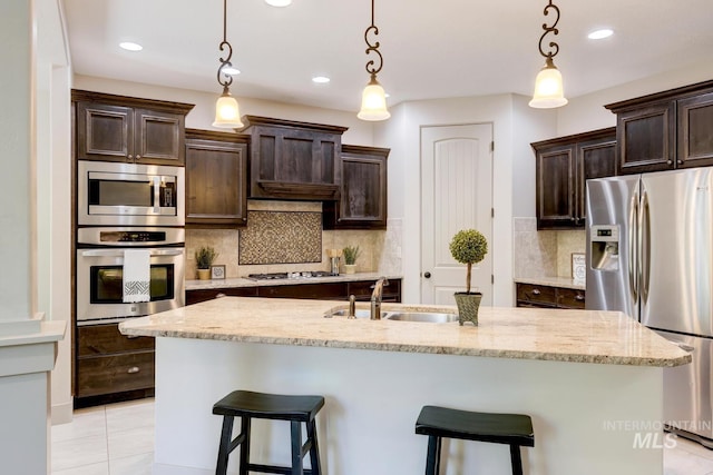 kitchen with stainless steel appliances, a kitchen breakfast bar, tasteful backsplash, and dark brown cabinets