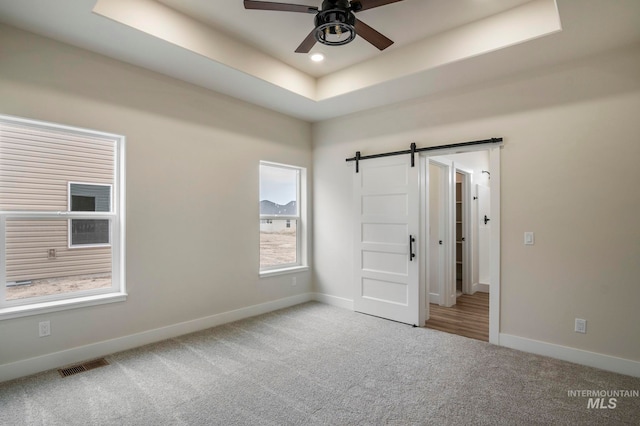 1100 Tanglewood St, Burley, ID 83318 - unfurnished bedroom featuring baseboards, a barn door, carpet, and a raised ceiling