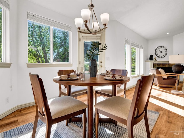 dining area with light wood finished floors, a chandelier, and baseboards