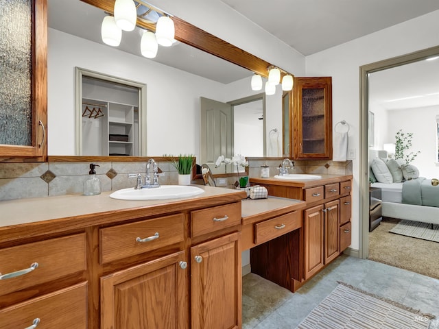 ensuite bathroom featuring tasteful backsplash, double vanity, and a spacious closet