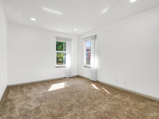 empty room with carpet flooring, baseboards, and recessed lighting