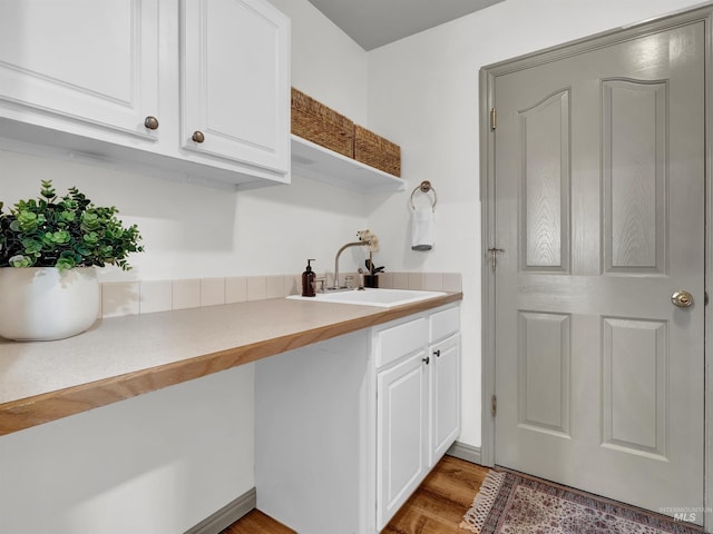 laundry area with a sink and light wood-style floors