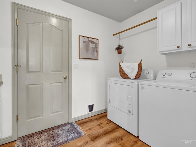 laundry area with cabinet space, separate washer and dryer, and light wood-style flooring