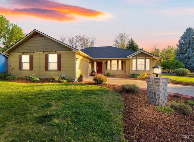 ranch-style home featuring an attached garage, a yard, and concrete driveway
