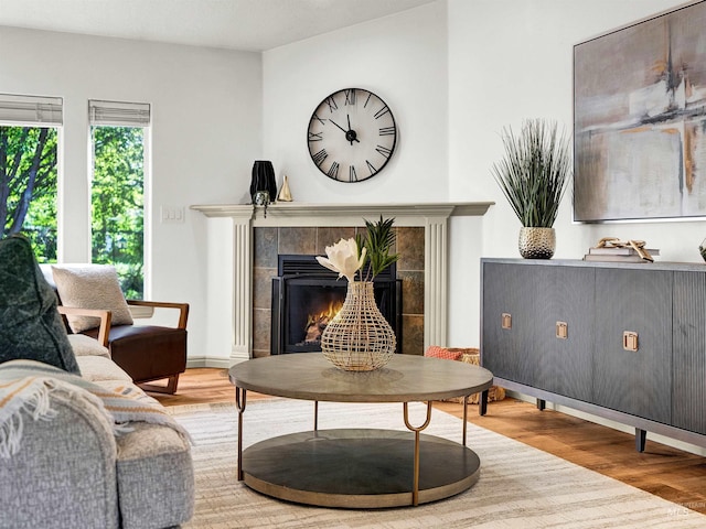 living area with wood finished floors and a tile fireplace