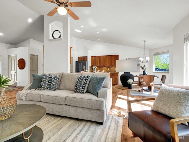 living room featuring a chandelier, light wood-style floors, ceiling fan, recessed lighting, and high vaulted ceiling