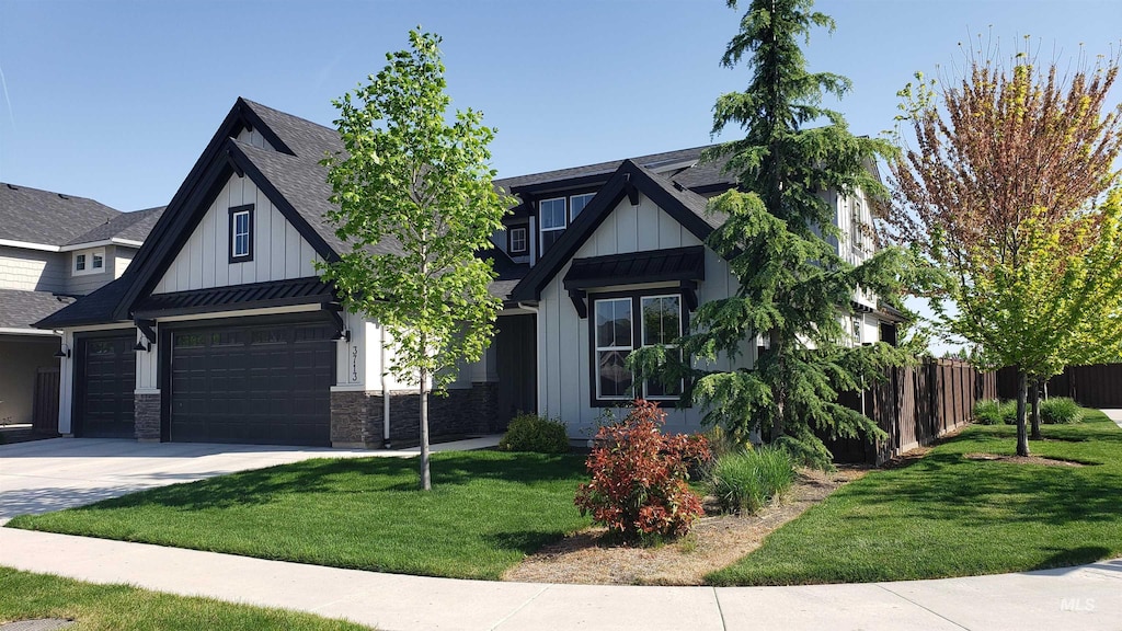 view of front of home with board and batten siding, fence, a front yard, and concrete driveway