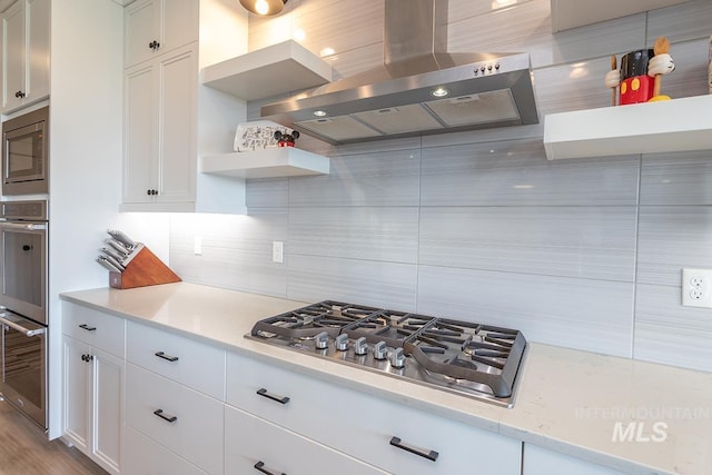 3713 W Ladle Rapids St, Meridian, ID 83646 - kitchen featuring stainless steel appliances, open shelves, wall chimney exhaust hood, decorative backsplash, and light countertops