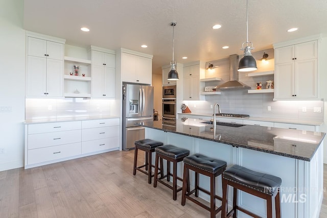 3713 W Ladle Rapids St, Meridian, ID 83646 - kitchen featuring light wood finished floors, open shelves, wall chimney range hood, tasteful backsplash, and appliances with stainless steel finishes