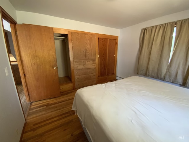 bedroom featuring dark hardwood / wood-style flooring and a closet