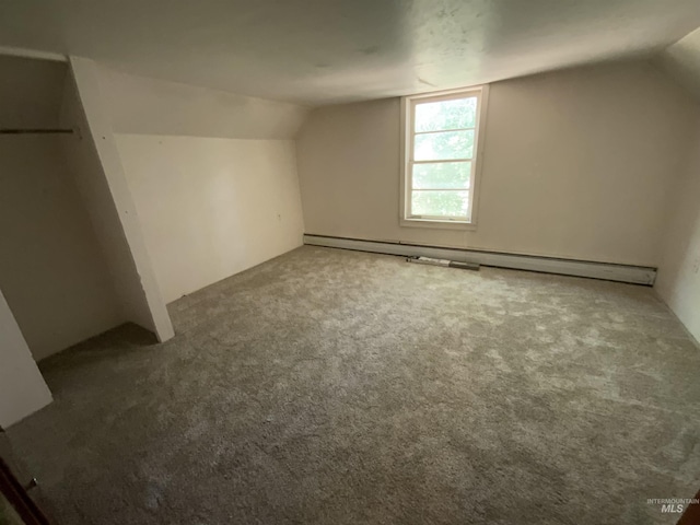 additional living space with vaulted ceiling, carpet flooring, and a baseboard radiator