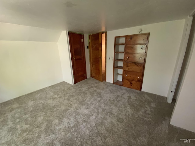 unfurnished bedroom with lofted ceiling and carpet flooring