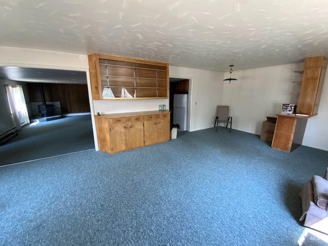 unfurnished living room featuring carpet and a textured ceiling