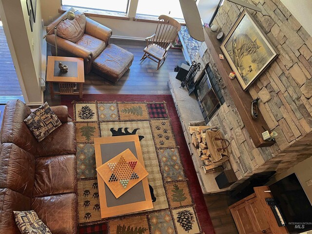 living area with baseboards, hardwood / wood-style flooring, and a fireplace