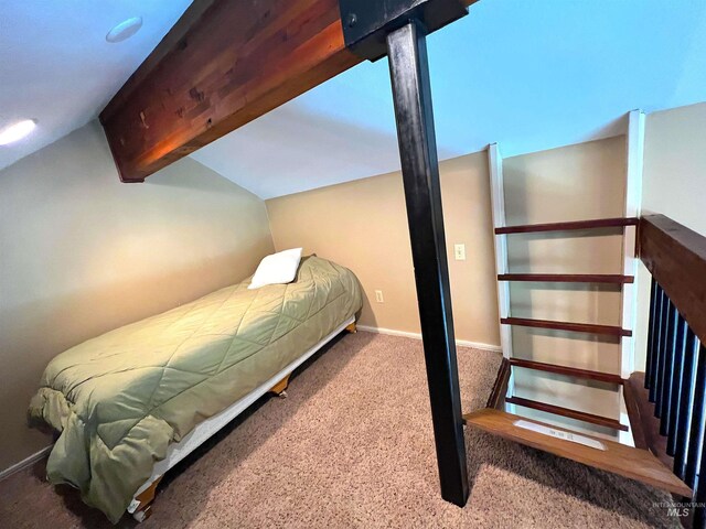 bedroom with carpet floors, baseboards, and lofted ceiling