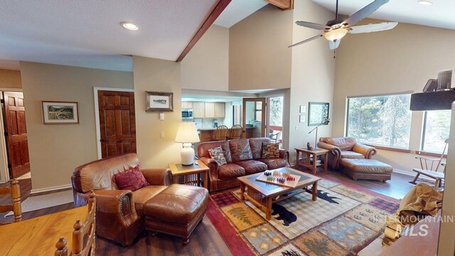 living area featuring recessed lighting, high vaulted ceiling, and wood finished floors