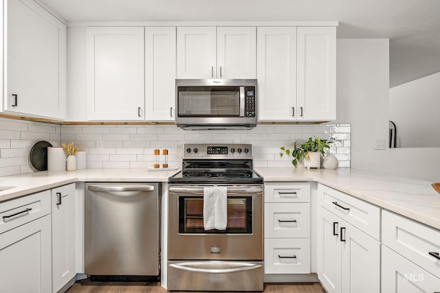64 Borah, Nampa, ID 83651 - kitchen with stainless steel appliances, white cabinetry, light countertops, tasteful backsplash, and light wood finished floors