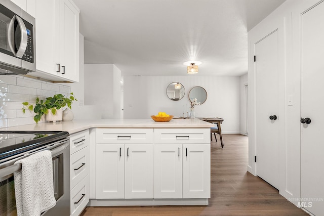 64 Borah, Nampa, ID 83651 - kitchen with stainless steel appliances, a peninsula, backsplash, and white cabinetry