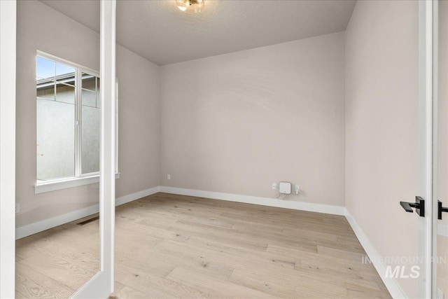 spare room with light wood-type flooring and a healthy amount of sunlight