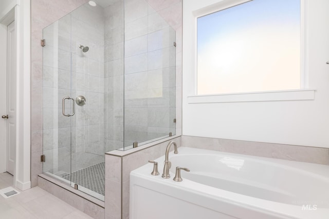 bathroom with independent shower and bath and tile patterned flooring