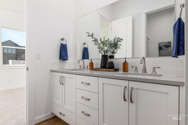 kitchen featuring white cabinetry, sink, a center island with sink, and dark wood-type flooring