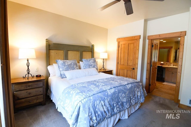 bedroom with connected bathroom, a ceiling fan, and carpet