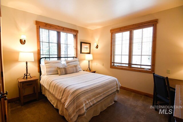 bedroom with baseboards and dark colored carpet