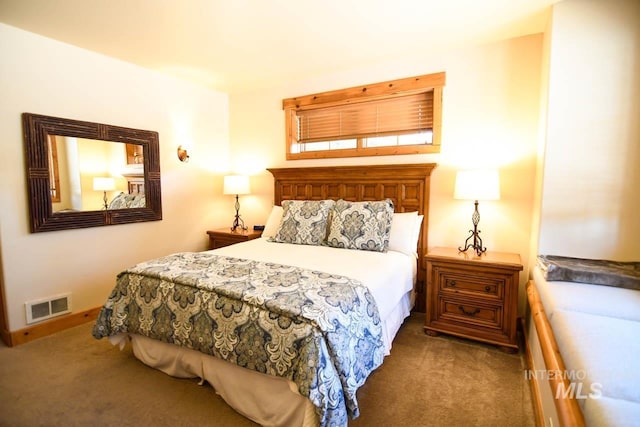 bedroom with baseboards, visible vents, and carpet