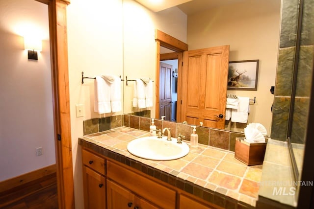 bathroom with vanity, baseboards, and wood finished floors