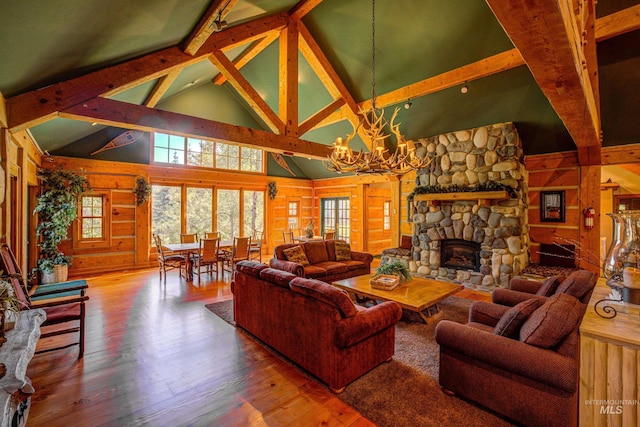 living area with wooden walls, a chandelier, high vaulted ceiling, and beamed ceiling