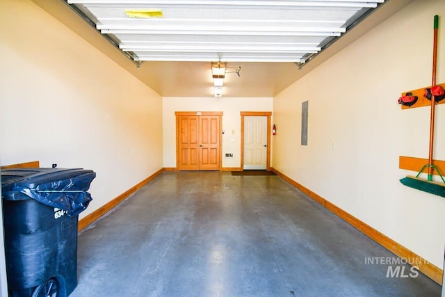garage featuring baseboards, a garage door opener, and electric panel
