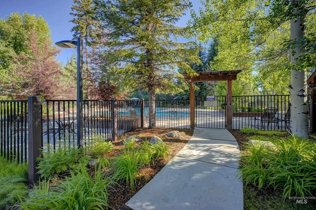 view of gate featuring a community pool and fence