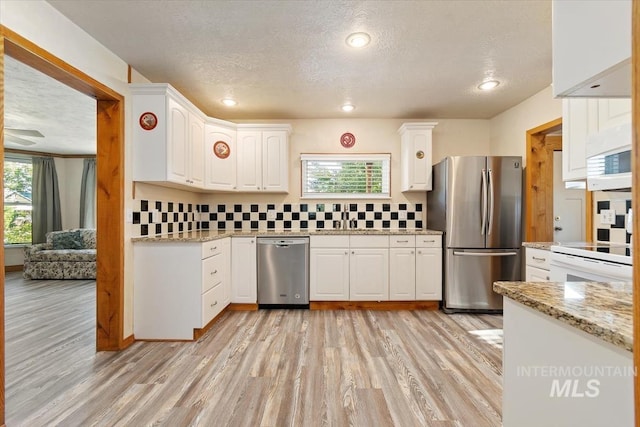 316 Maple Ave, Emmett, ID 83617 - kitchen featuring appliances with stainless steel finishes, a textured ceiling, light wood-type flooring, a sink, and healthy amount of natural light