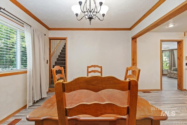 316 Maple Ave, Emmett, ID 83617 - dining space featuring wood finished floors, baseboards, a chandelier, stairway, and ornamental molding