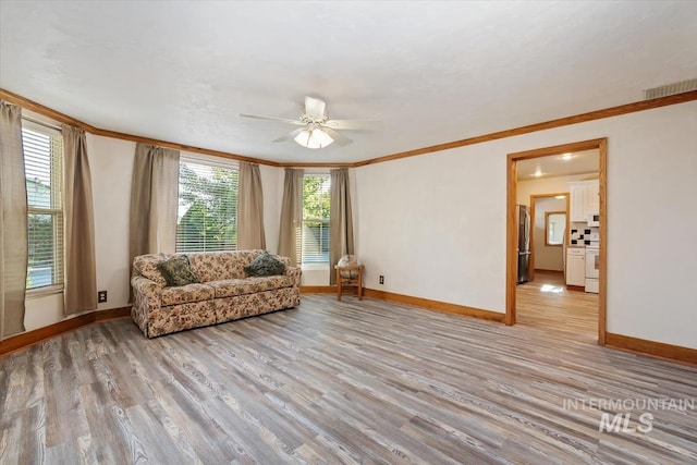 316 Maple Ave, Emmett, ID 83617 - living area featuring light wood-style floors, ornamental molding, a ceiling fan, and baseboards