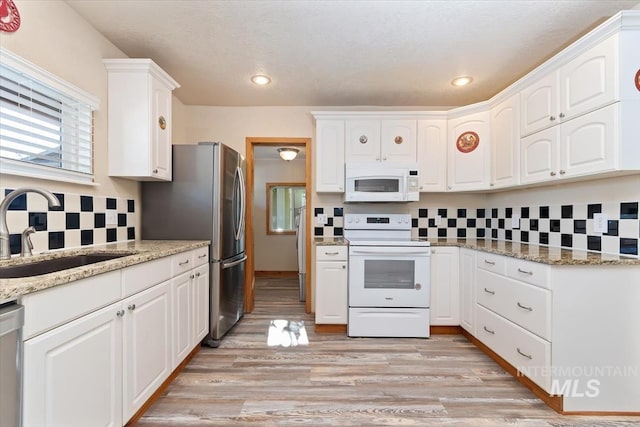 316 Maple Ave, Emmett, ID 83617 - kitchen with white appliances, a sink, tasteful backsplash, white cabinets, and light stone counters