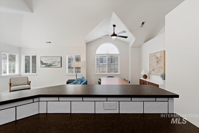 kitchen featuring vaulted ceiling, a ceiling fan, open floor plan, and visible vents