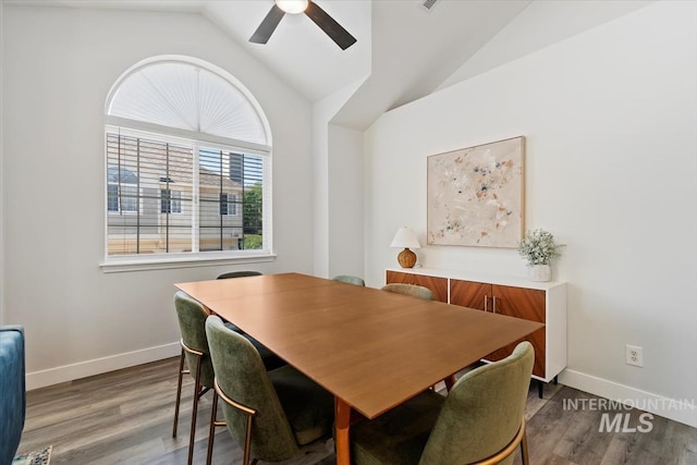 dining area featuring ceiling fan, baseboards, wood finished floors, and vaulted ceiling