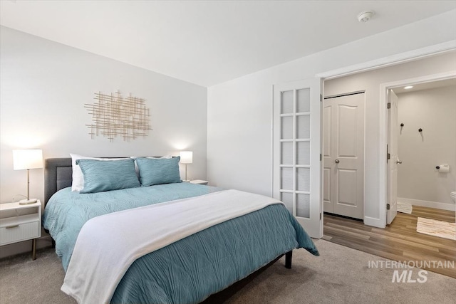 bedroom with wood finished floors and baseboards