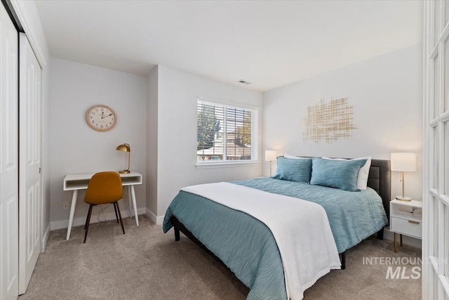 carpeted bedroom with baseboards, visible vents, and a closet