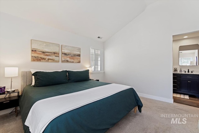 bedroom featuring baseboards, visible vents, high vaulted ceiling, ensuite bathroom, and light carpet