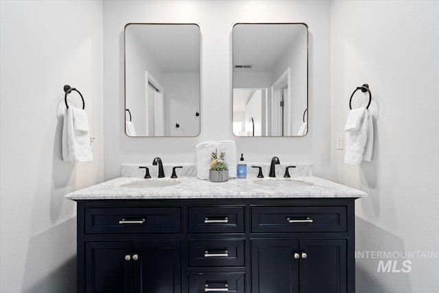 bathroom featuring a sink and double vanity