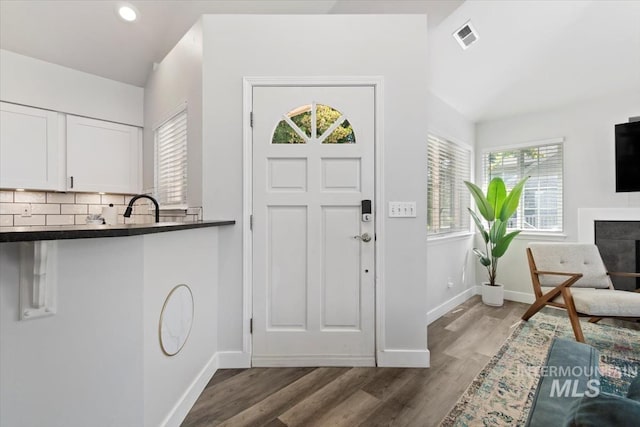 entrance foyer featuring visible vents, wood finished floors, recessed lighting, a fireplace, and baseboards