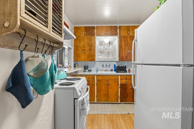 2517/2519 N 21st, Boise, ID 83702 - kitchen featuring white appliances, brown cabinets, a sink, and light wood-style floors