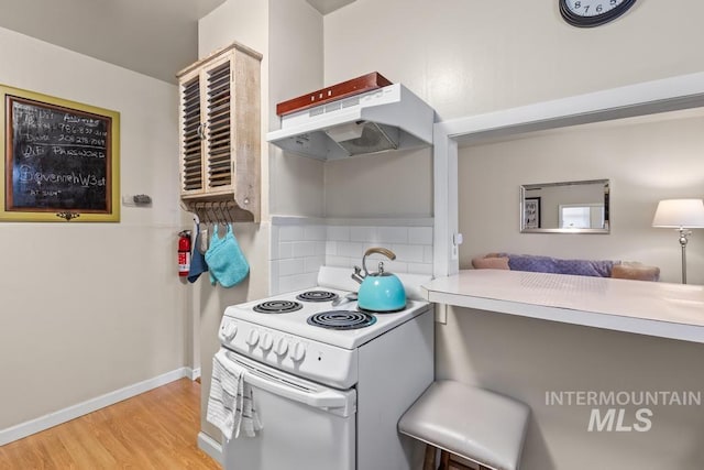 2517/2519 N 21st, Boise, ID 83702 - kitchen with tasteful backsplash, baseboards, under cabinet range hood, white electric stove, and wood finished floors