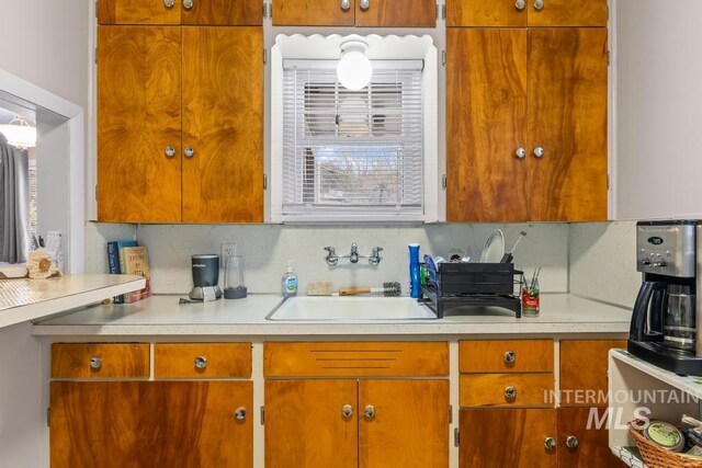 2517/2519 N 21st, Boise, ID 83702 - kitchen featuring light countertops, a sink, brown cabinets, and decorative backsplash