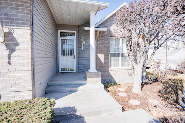 view of exterior entry with brick siding